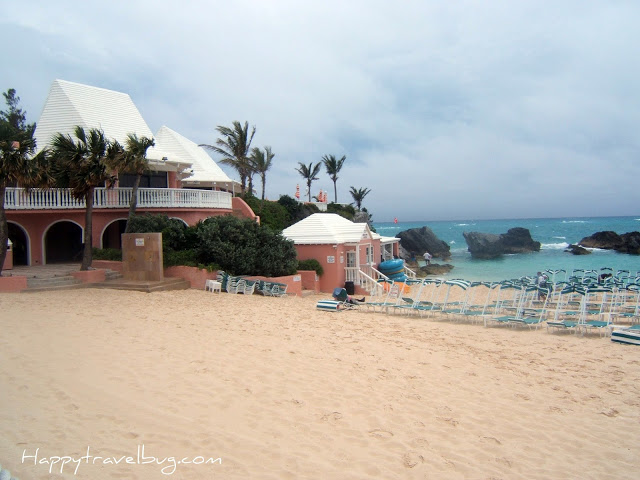 Pink Bermuda Sand with a pink building  and lounge chairs