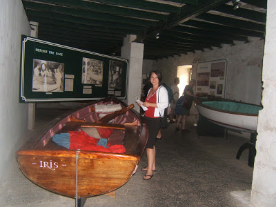 Woman next to a wooden boat in a museum