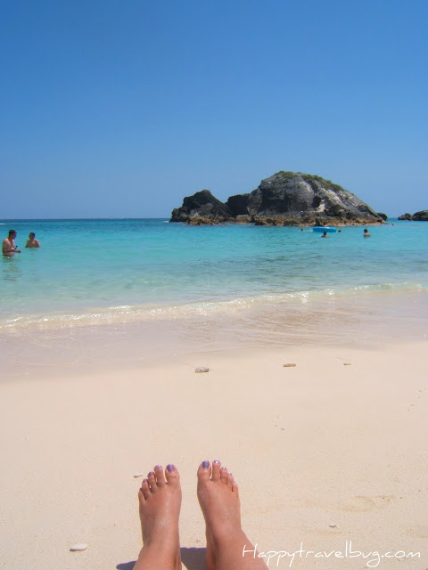 Pink Sand beach in Bermuda with a woman's feet showing on the sand