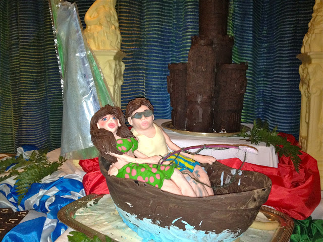 dessert buffet sculpture of people in a boat with a castle in the background