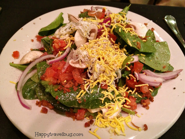 Spinach salad with cheese, tomatoes, onions, bacon and mushrooms