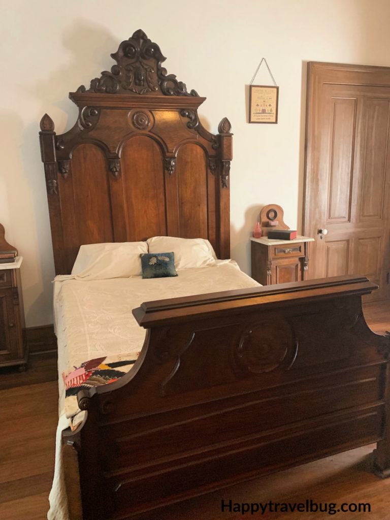 Antique wooden bed with a white bedspread