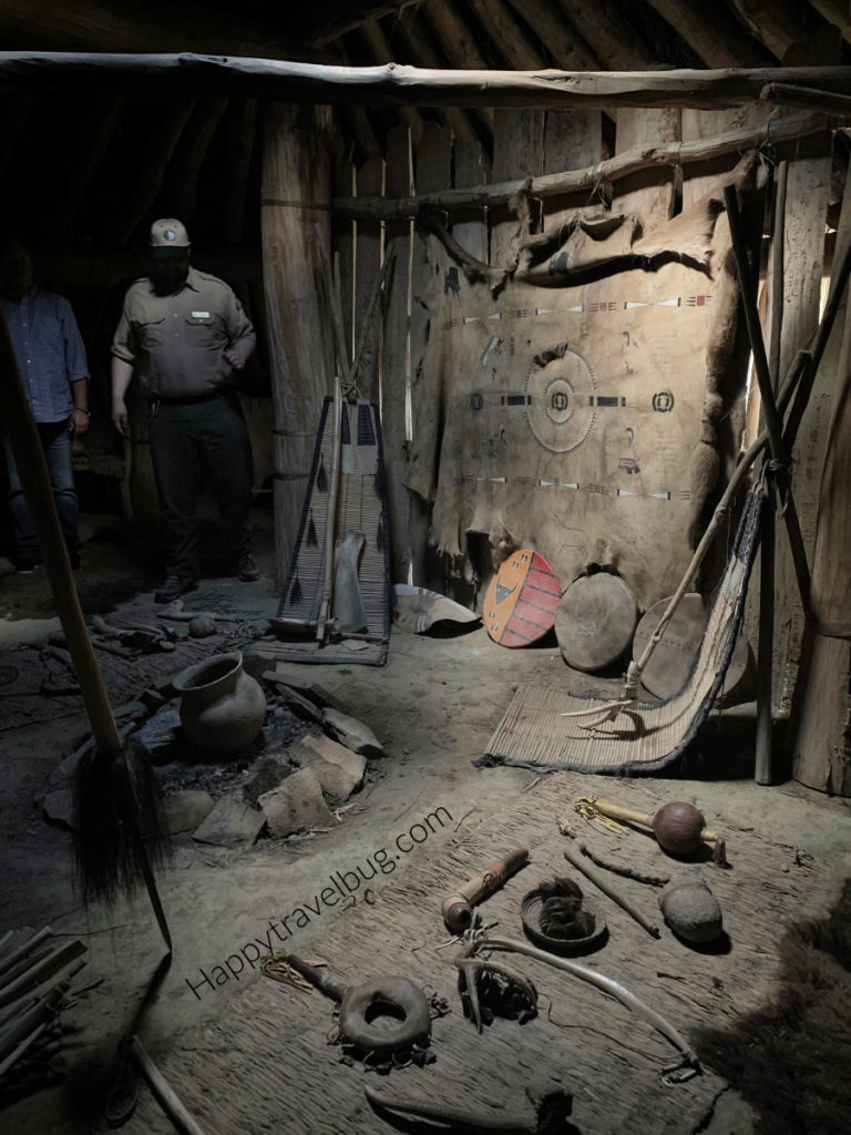 Inside the earth lodge showing lots of Indian tools