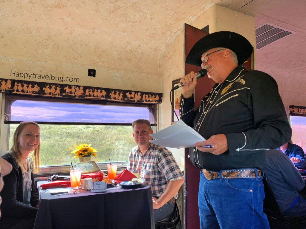 Cowboy on a train talking into a microphone