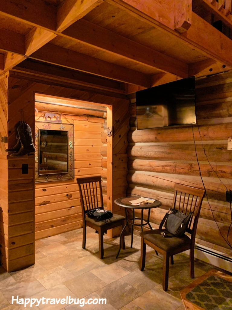table and 2 chairs in log cabin