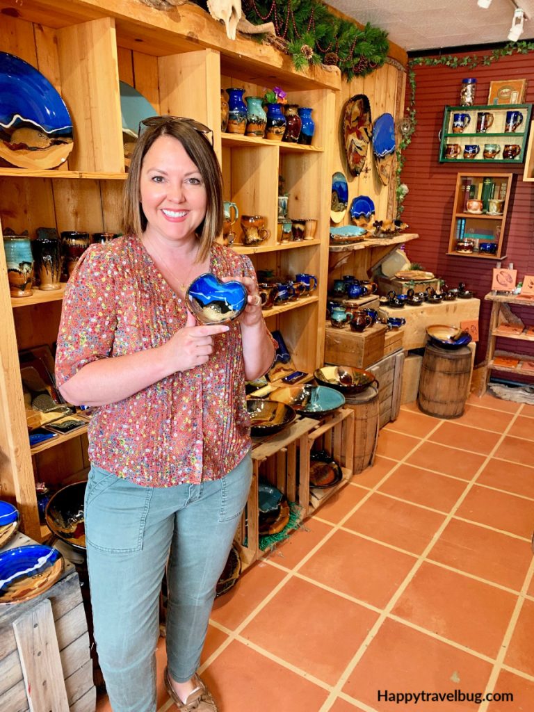 Woman in a pottery store holding a heart shaped bowl