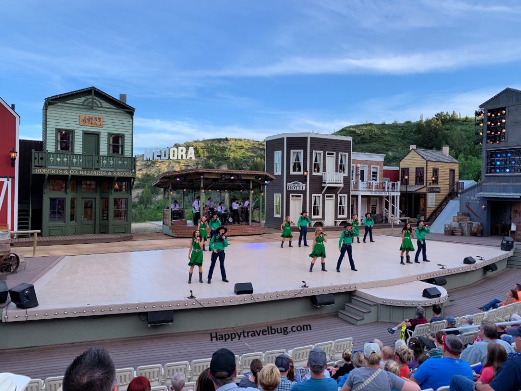 Dancers on a stage with a fake western town backdrop