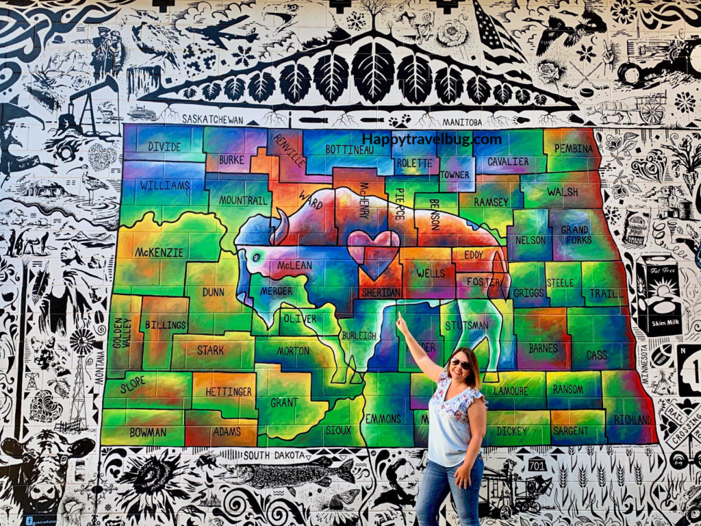 woman pointing to a mural of North Dakota